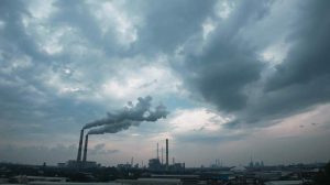 Pemandangan kawasan industri Gresik dengan latar belakang cerobong asap dan langit berawan sebagai simbol tantangan polusi udara